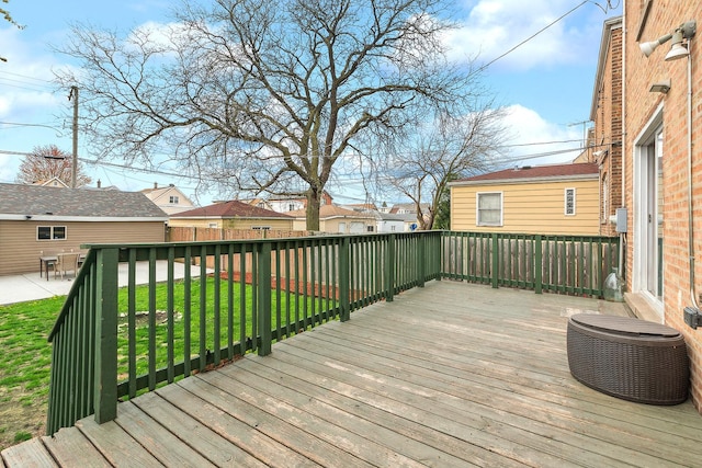wooden terrace featuring fence, a yard, and a residential view