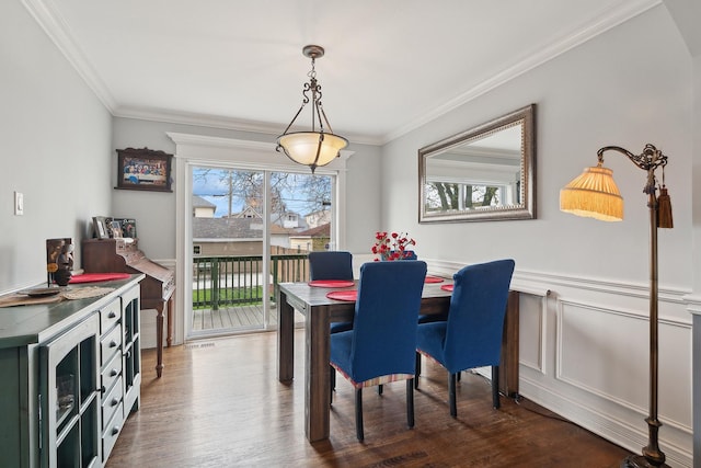 dining area with wainscoting, dark wood finished floors, and ornamental molding