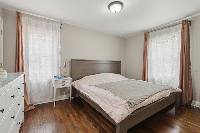 bedroom with dark wood-style flooring
