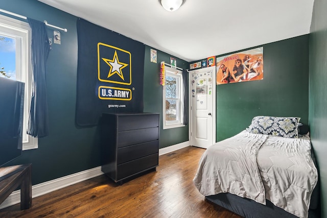 bedroom with baseboards and wood finished floors