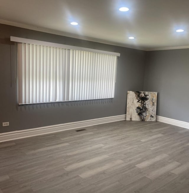 interior space featuring baseboards, ornamental molding, recessed lighting, and wood finished floors
