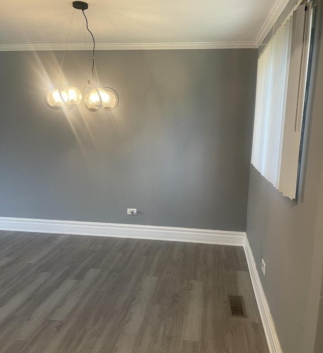 unfurnished dining area featuring visible vents, baseboards, a chandelier, ornamental molding, and dark wood-type flooring