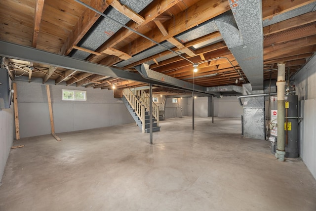basement featuring stairway, gas water heater, and electric panel
