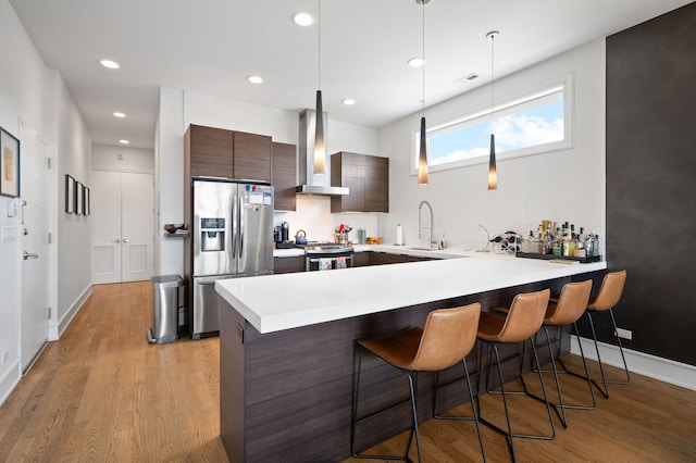 2424 W Chicago Ave Unit 203, Chicago, IL 60622 - kitchen featuring wall chimney range hood, a sink, stainless steel appliances, a peninsula, and modern cabinets