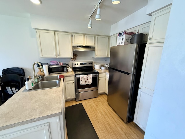 353 S Whispering Hills Dr Unit C, Naperville, IL 60540 - kitchen featuring light countertops, under cabinet range hood, a sink, light wood finished floors, and appliances with stainless steel finishes