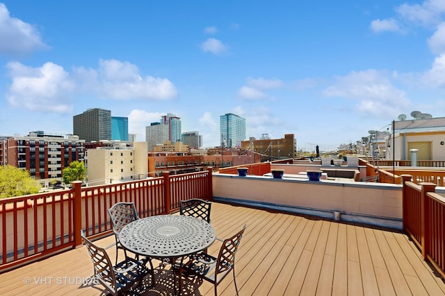 wooden terrace featuring a city view and outdoor dining space