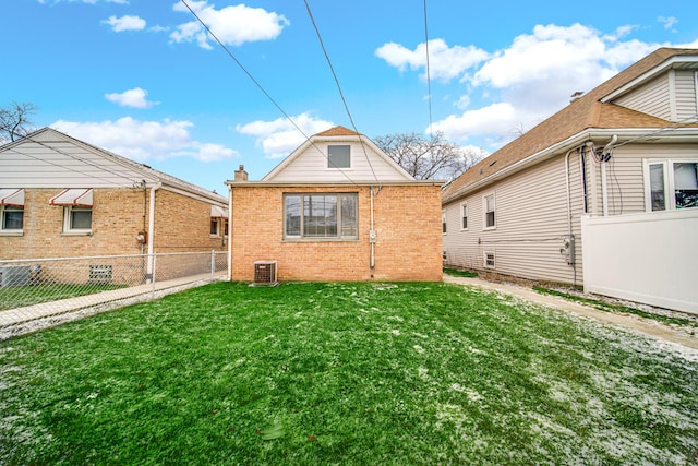 rear view of property with a lawn, central AC, fence, and brick siding