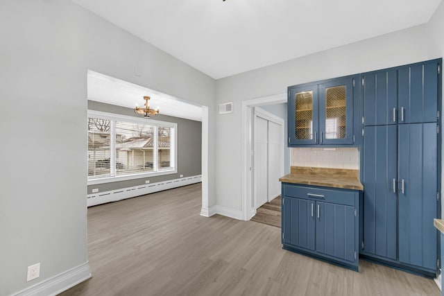 kitchen with visible vents, a baseboard radiator, wood counters, and blue cabinets