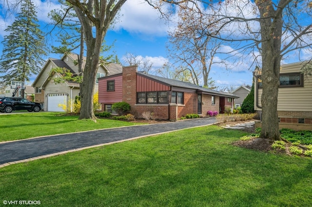 view of front of house featuring brick siding, driveway, and a front yard