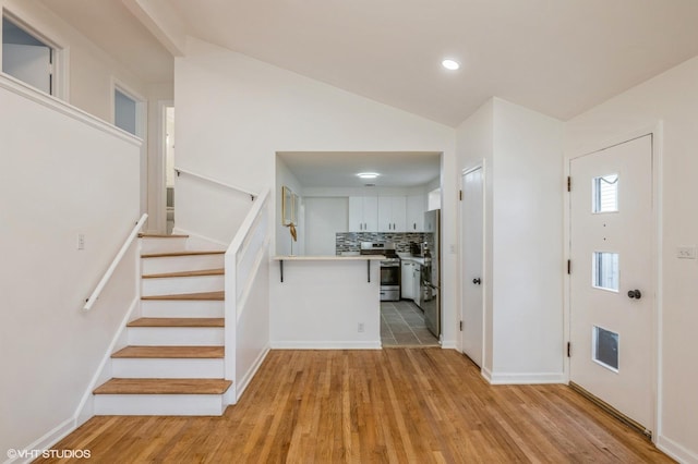 foyer entrance featuring vaulted ceiling, stairway, baseboards, recessed lighting, and light wood-style flooring