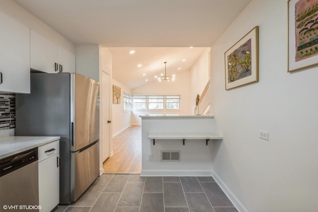 kitchen with white cabinets, appliances with stainless steel finishes, light countertops, a chandelier, and visible vents