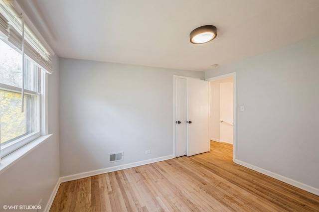 spare room with visible vents, baseboards, and light wood-type flooring