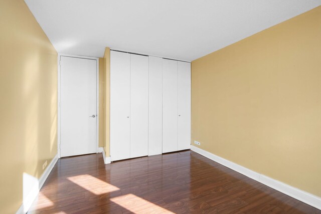 6700 S S Shore Dr Unit 10J, Chicago, IL 60649 - unfurnished bedroom with dark wood-type flooring, baseboards, and a closet