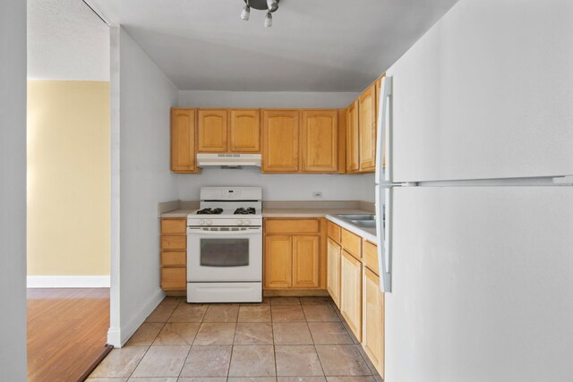 6700 S S Shore Dr Unit 10J, Chicago, IL 60649 - kitchen with light countertops, baseboards, a sink, under cabinet range hood, and white appliances