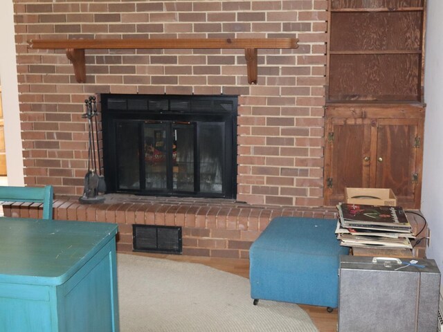 1605 Sharon Rd, Streator, IL 61364 - interior details with a brick fireplace, visible vents, and wood finished floors