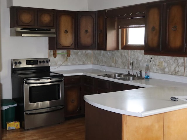 1605 Sharon Rd, Streator, IL 61364 - kitchen with electric range, a peninsula, light countertops, under cabinet range hood, and a sink