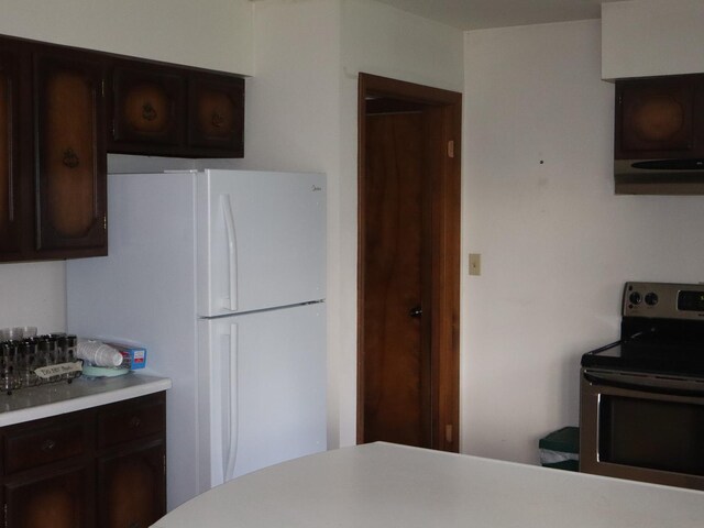 1605 Sharon Rd, Streator, IL 61364 - kitchen with light countertops, freestanding refrigerator, dark brown cabinets, and stainless steel electric range oven