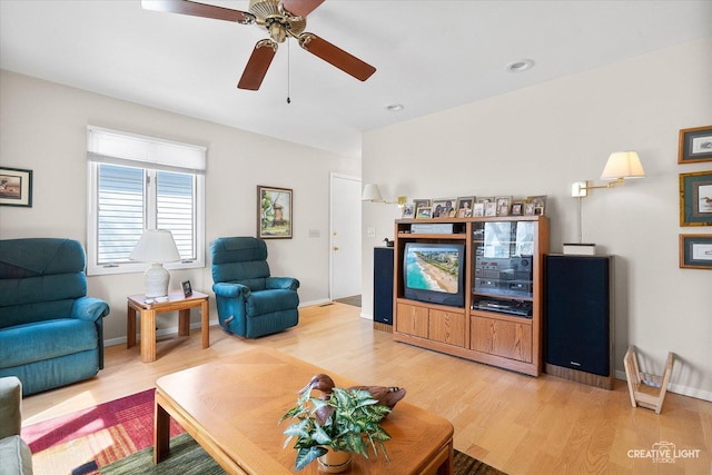 living room with a ceiling fan and light wood-type flooring