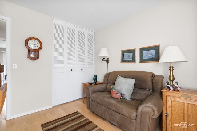 living area featuring baseboards and light wood finished floors