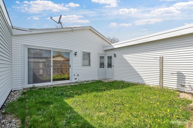 rear view of property featuring a lawn