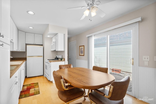 dining space with a ceiling fan, recessed lighting, wainscoting, and light wood finished floors