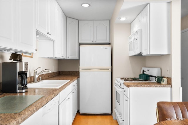 kitchen with white appliances, recessed lighting, white cabinets, and a sink
