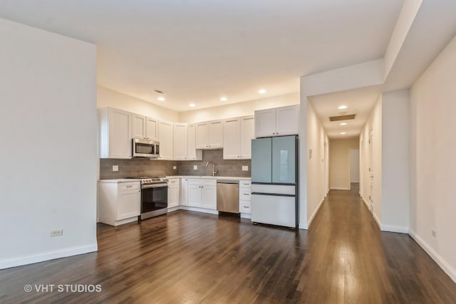 kitchen with light countertops, stainless steel appliances, baseboards, tasteful backsplash, and visible vents