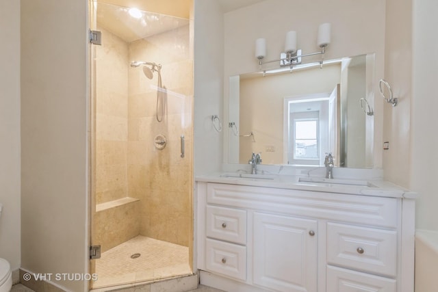 full bath featuring a sink, a stall shower, toilet, and double vanity