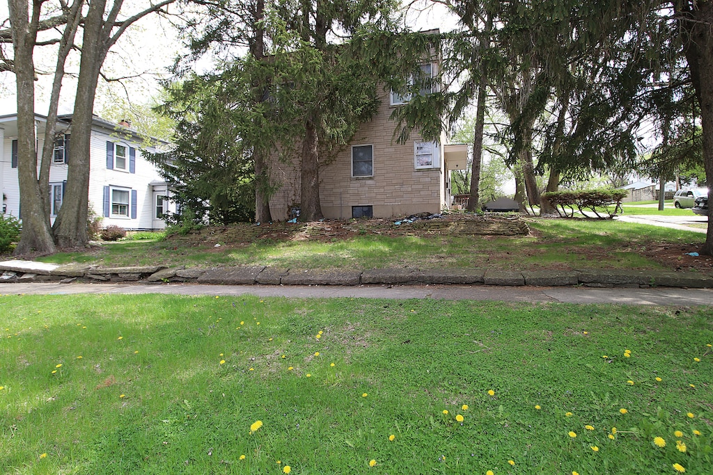 view of property exterior with brick siding and a lawn