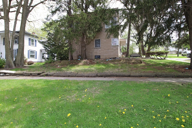 view of property exterior with brick siding and a lawn