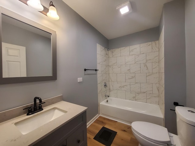 bathroom with vanity, washtub / shower combination, wood finished floors, and toilet