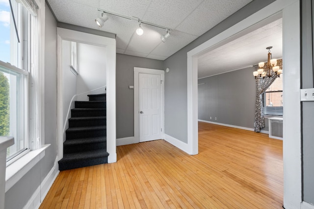 809 W Touhy Ave, Park Ridge, IL 60068 - interior space featuring rail lighting, baseboards, a chandelier, stairs, and hardwood / wood-style floors