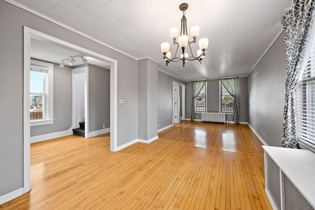 809 W Touhy Ave, Park Ridge, IL 60068 - interior space featuring crown molding, light wood-style floors, radiator heating unit, stairway, and a chandelier