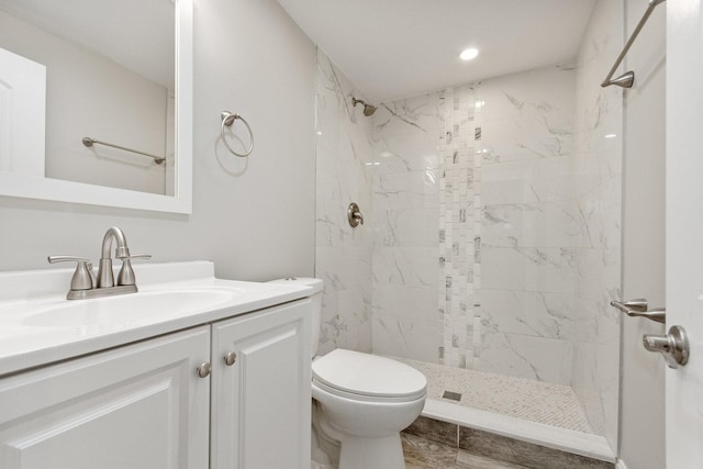 full bathroom with recessed lighting, vanity, toilet, and a marble finish shower