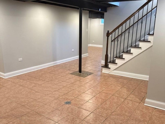 finished basement featuring baseboards and stairs