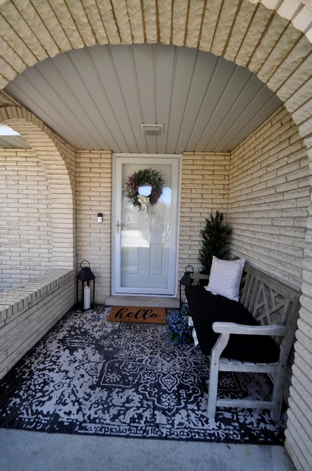 view of exterior entry featuring brick siding