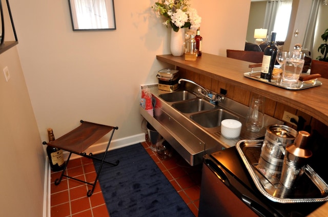 interior space featuring tile patterned floors, a sink, and baseboards