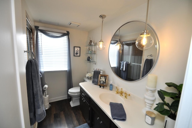 bathroom featuring vanity, baseboards, wood finished floors, and toilet