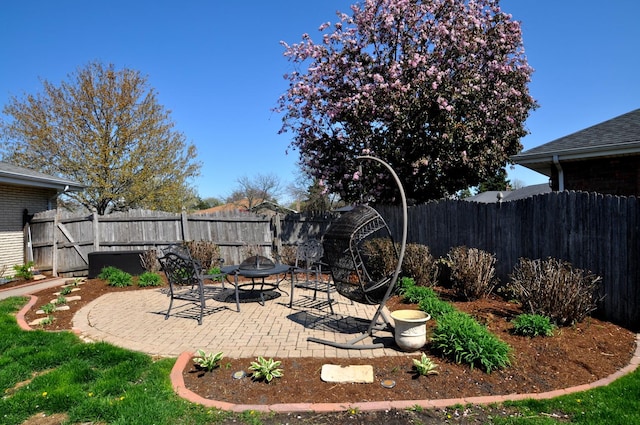 view of yard featuring a fenced backyard, cooling unit, a fire pit, and a patio area