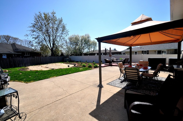 view of patio featuring a gazebo, a fenced backyard, and outdoor dining space
