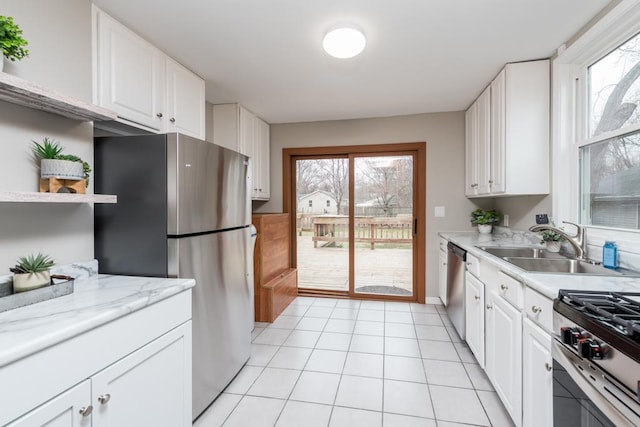 kitchen featuring a sink, white cabinetry, appliances with stainless steel finishes, and light tile patterned flooring