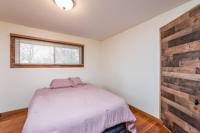 bedroom with baseboards and wood finished floors