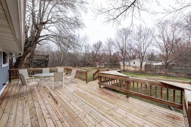 wooden terrace featuring a fenced backyard and outdoor dining space