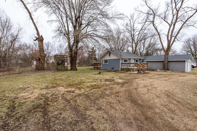 view of yard featuring a deck and an outbuilding