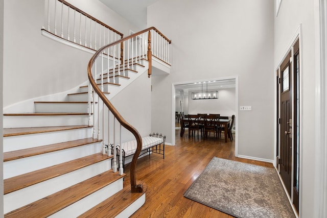 3130 Kayjay Dr, Northbrook, IL 60062 - foyer with wood finished floors, a towering ceiling, stairway, a notable chandelier, and baseboards