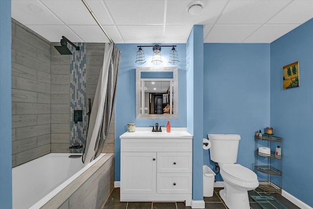 full bathroom featuring tiled shower / bath combo, toilet, baseboards, tile patterned flooring, and a paneled ceiling