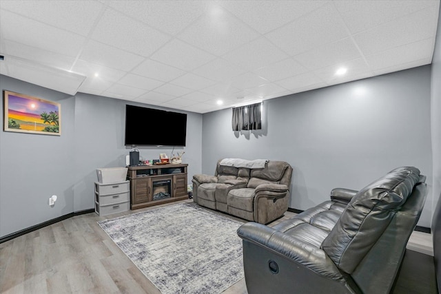 living room with light wood finished floors, recessed lighting, baseboards, and a drop ceiling