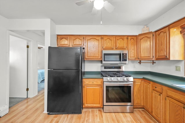 kitchen with stainless steel appliances, light wood-style flooring, brown cabinets, and a ceiling fan