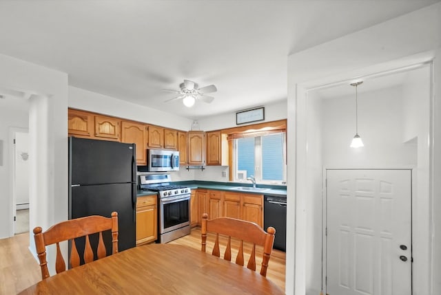 kitchen with black appliances, a sink, light wood-style flooring, and ceiling fan