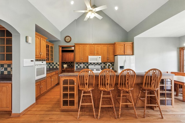 3664 E 2619th Rd, Sheridan, IL 60551 - kitchen featuring white appliances, high vaulted ceiling, an island with sink, dark countertops, and a ceiling fan